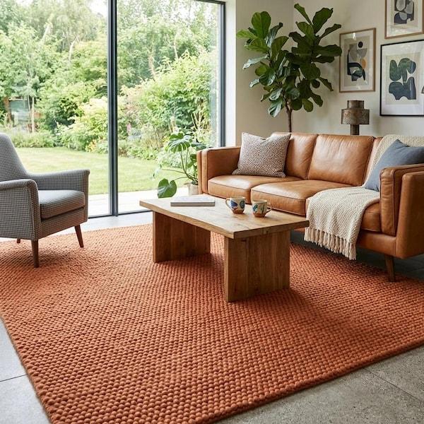 Rust orange felt pebble rectangular rug in living room