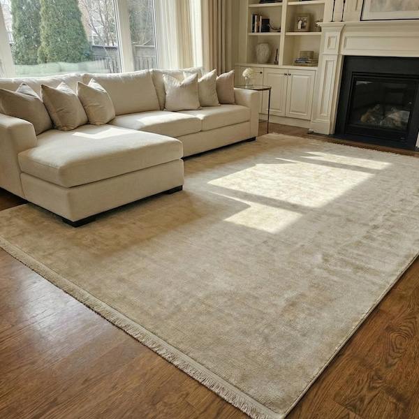 Ivory cream silk rug in living room by fireplace