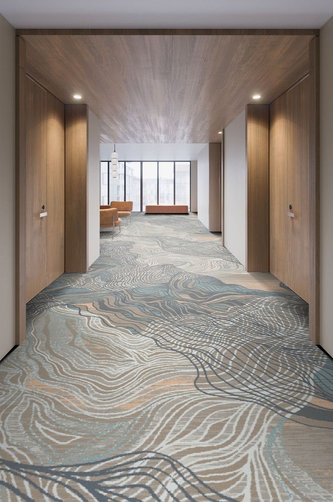 Teal and beige organic wave pattern wall to wall carpet with wood paneling