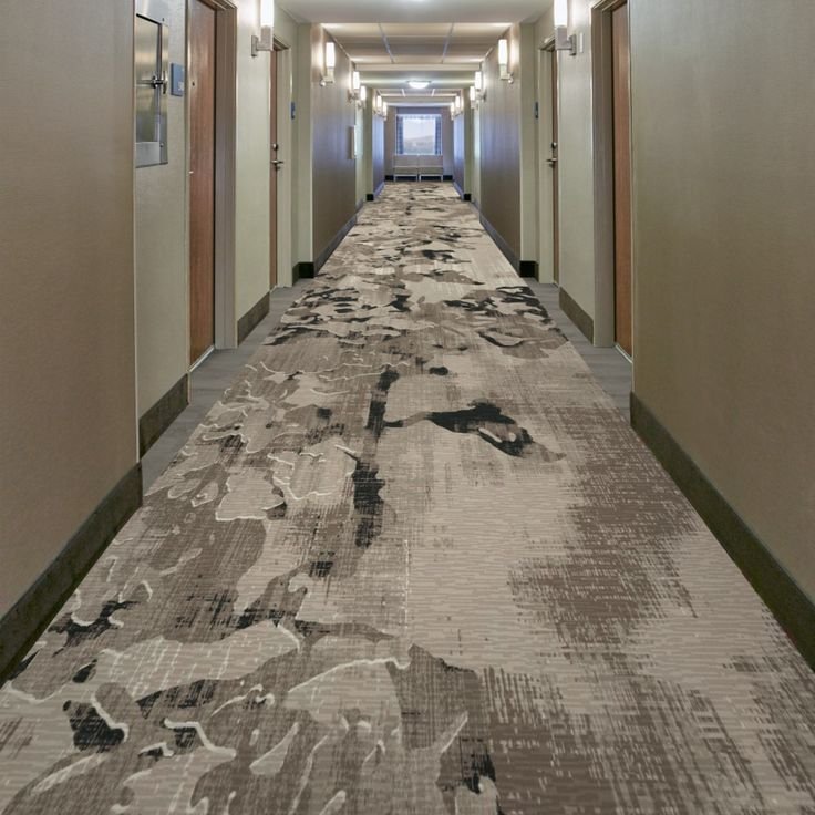 Charcoal and taupe camouflage pattern wall to wall carpet in hotel hallway