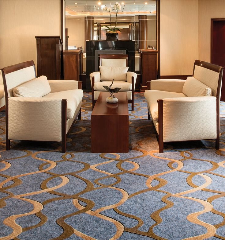 Cobalt blue and gold ribbon swirl pattern wall to wall carpet in lounge seating area