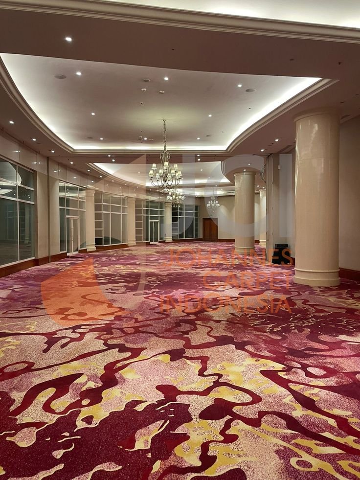 Crimson red and gold marbled pattern wall to wall carpet in grand ballroom
